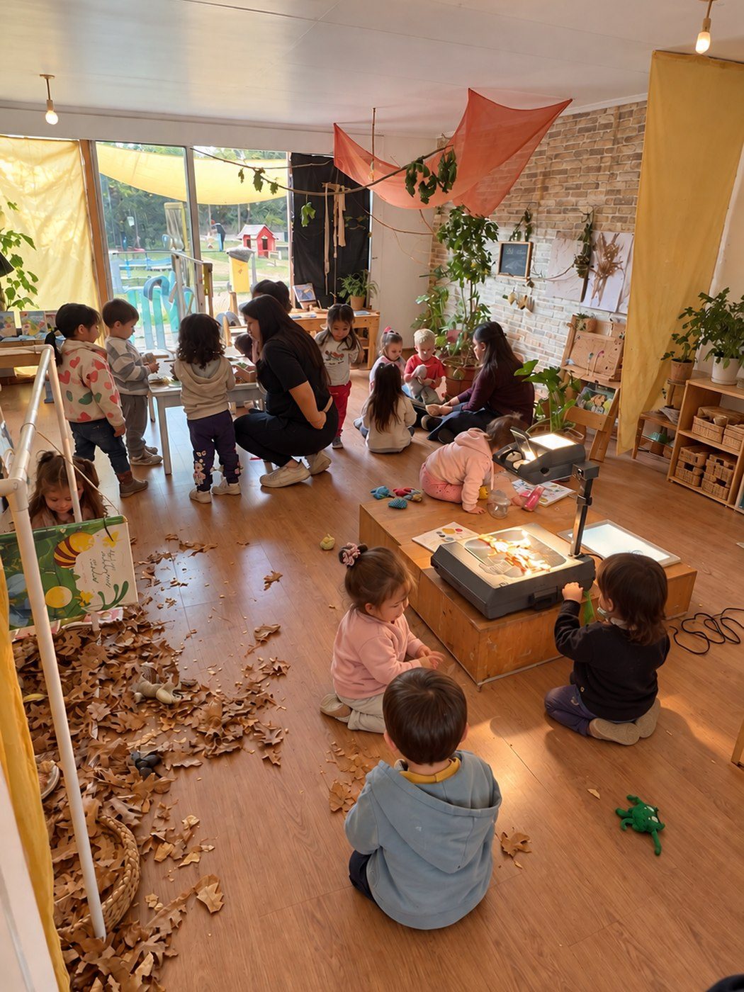 Ni&ntilde;os y ni&ntilde;as explorando en el Atelier Abierto de Bianca Stella, con mesas de luz y hojas secas